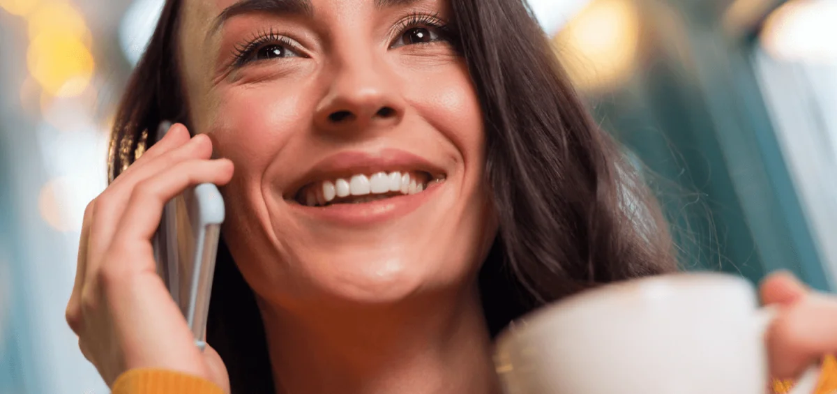 woman holding phone and coffee