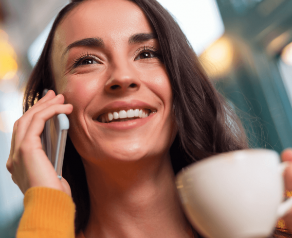 woman holding phone and coffee
